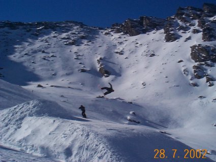 Snowboarders showing off there agility on the slopes